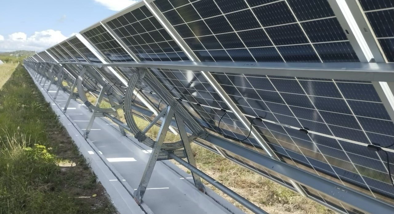 Slipform extruded ballast under an A-frame tracker